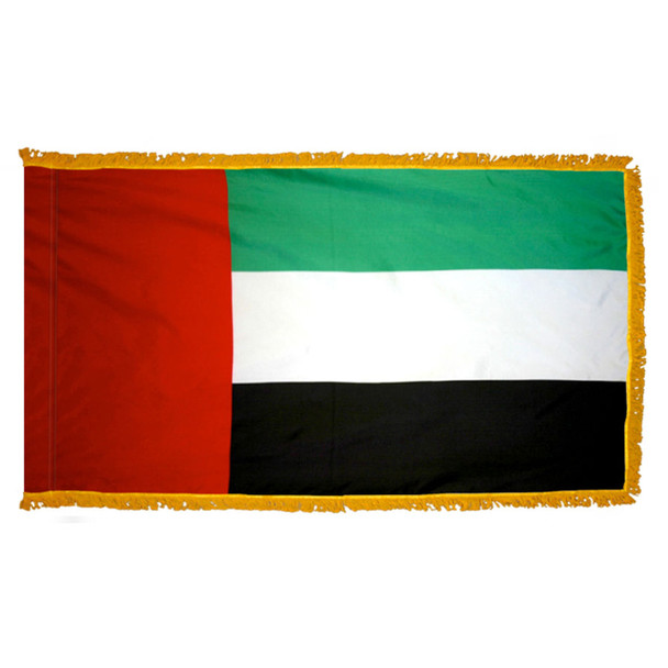 The indoor UAE flag has 3 sides of gold fringe around a horizontal green, white, and black tricolor. On the left is a vertical red stripe.