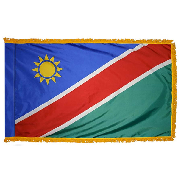 The indoor Namibia flag has 3 sides of gold fringe around blue & green fields separated by a diagonal red line with a sun in the upper left.