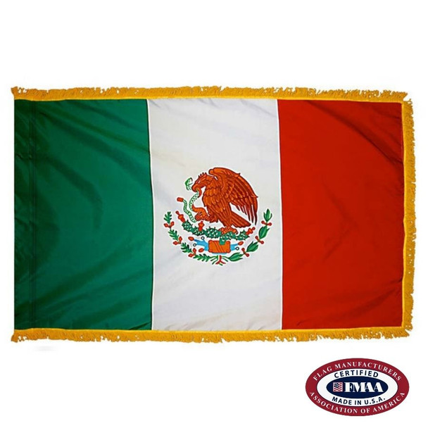 The indoor Mexico flag has 3 sides of gold fringe around a vertical green, white, & red tricolor. In the center is an eagle holding a snake. FMAA Certified Made in America seal.