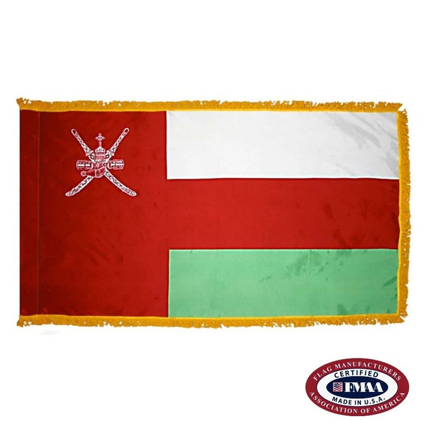The indoor Oman flag has 3 sides of gold fringe around a white, red, and green tricolor. On the left is a red field with the national emblem. FMAA Certified Made in America seal.