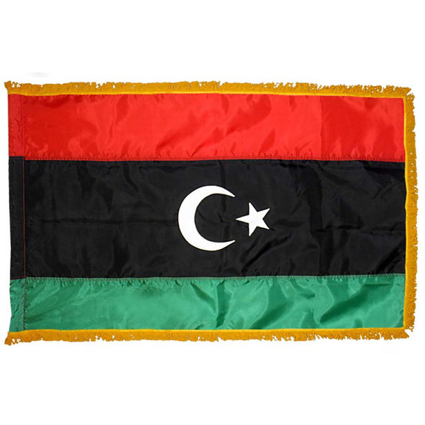 The indoor Libya flag has 3 sides of gold fringe around a red, black, and green tricolor. In the wide black stripe is a crescent and star.