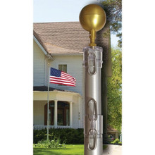 The T20 20’ Telescoping Flagpole stands in front of a house with an American flag sitting atop it. In the photo’s foreground is a close-up shot of the top of the flagpole, showing the gold-painted aluminum decorative ball, the flagpole’s polycarbonate cap, and halyard snaps for easy attachment to your flagpole.