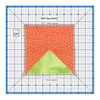 Image showing the Large Get Squared Ruler by June Tailor in use, with a clear 12 1/2 inch square ruler marked with precise grid lines and blue accents over a piece of fabric, depicting a half square triangle quilt block for accurate measuring and cutting.