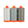 Three spools of Aurifil Milan 50wt Egyptian cotton thread in shades of grey on a white background