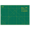 The image shows an OLFA RM-CG 12”x18” Double-Sided Rotary Mat in green with a detailed grid and measurement indicators in yellow. The mat includes various angled guidelines for precision cutting and features the OLFA logo and safety instructions in the top right corner.