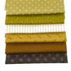 A neatly stacked set of five Andover Jewelbox Autumn fat quarters, featuring ditsy prints in a harmonious palette of mustard, cream, brown, and olive, showcasing intricate traditional patterns.