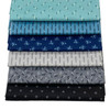 A collection of five neatly stacked Andover Jewelbox Winter fat quarters, featuring a variety of ditsy prints in shades of blue, grey, and black.