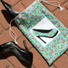 A handcrafted shoe bag with a high heel appliqué design on a floral fabric, lying next to a matching pair of black high-heeled shoes, showcasing the application of Therm-o-Web HeatnBond Lite.