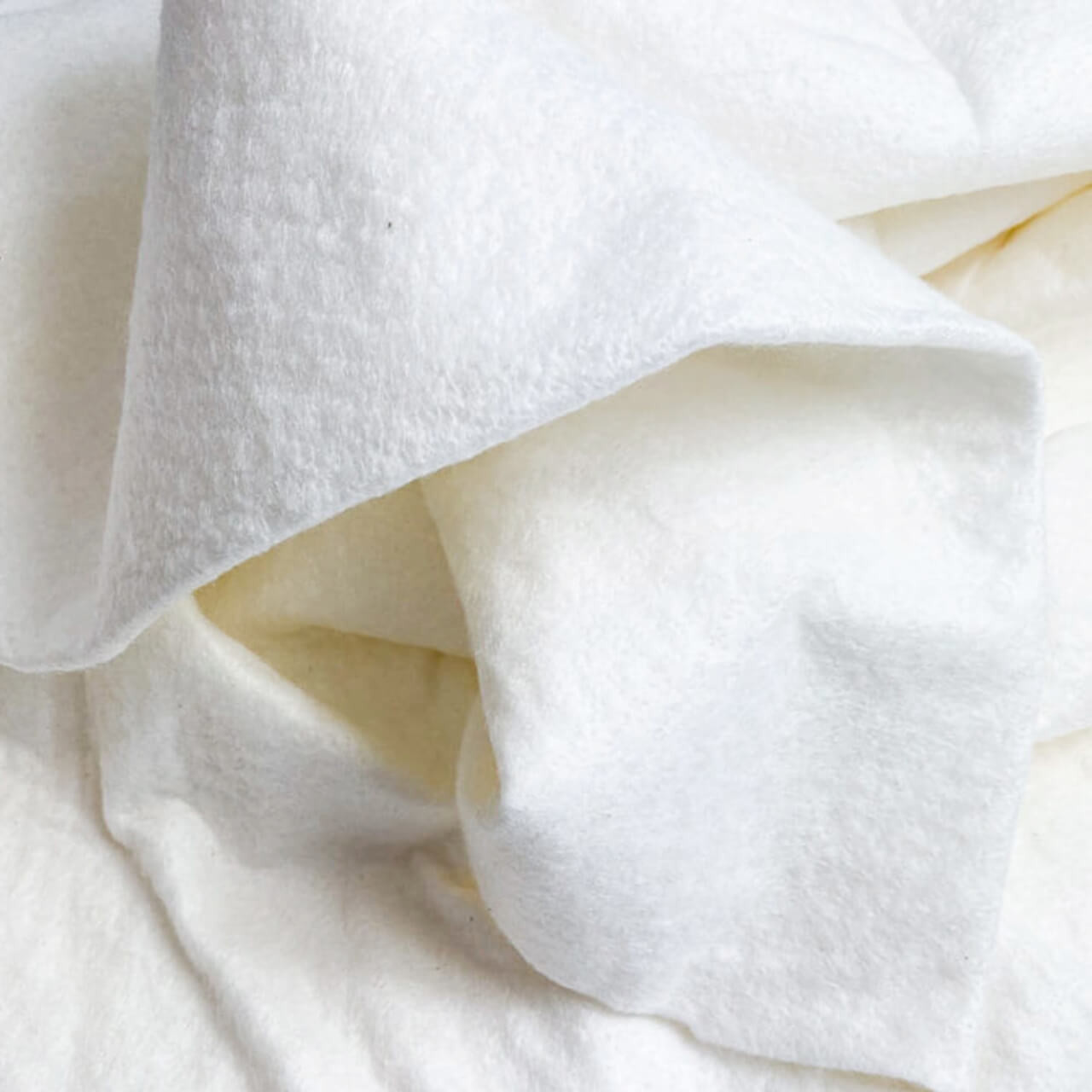 Soft, textured white Sew Simple Super Soft 100% Bamboo Wadding Remnants draped elegantly, highlighting the plush quality and versatility of the fabric.