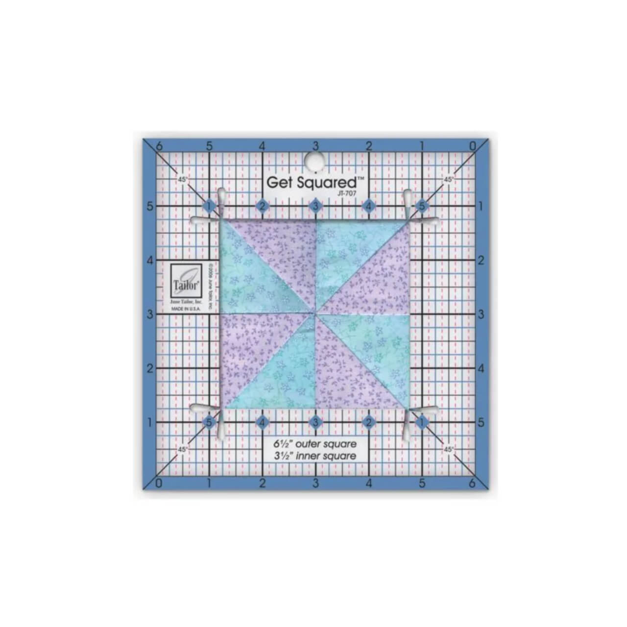 The Small Get Squared Ruler by June Tailor being used to measure and square up a patchwork quilt block with purple and blue fabrics, showcasing the clear central cutout and precise grid lines for accurate fabric cutting.