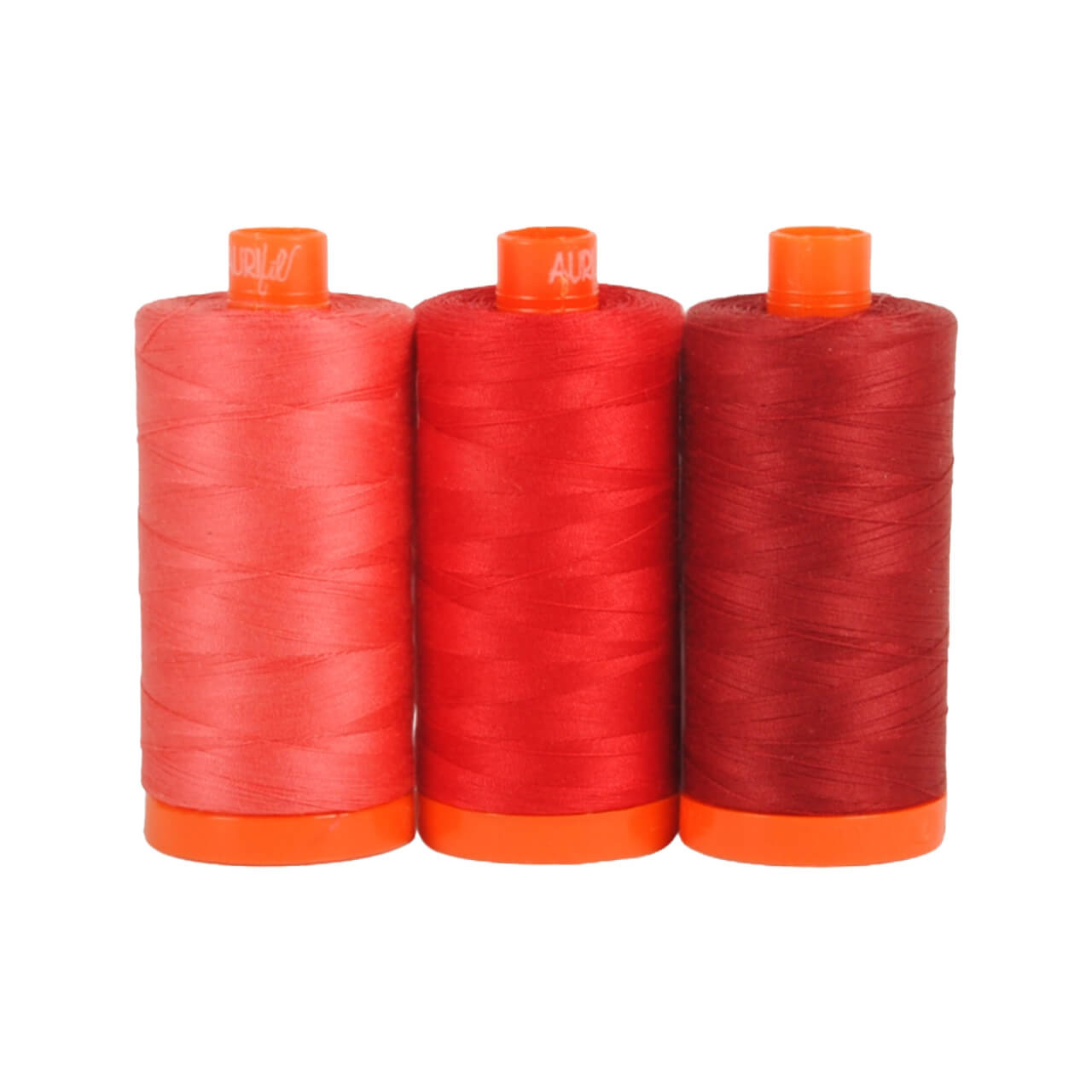 Three spools of Aurifil Pompeii 50wt Egyptian cotton thread in vibrant shades of red on a white background.