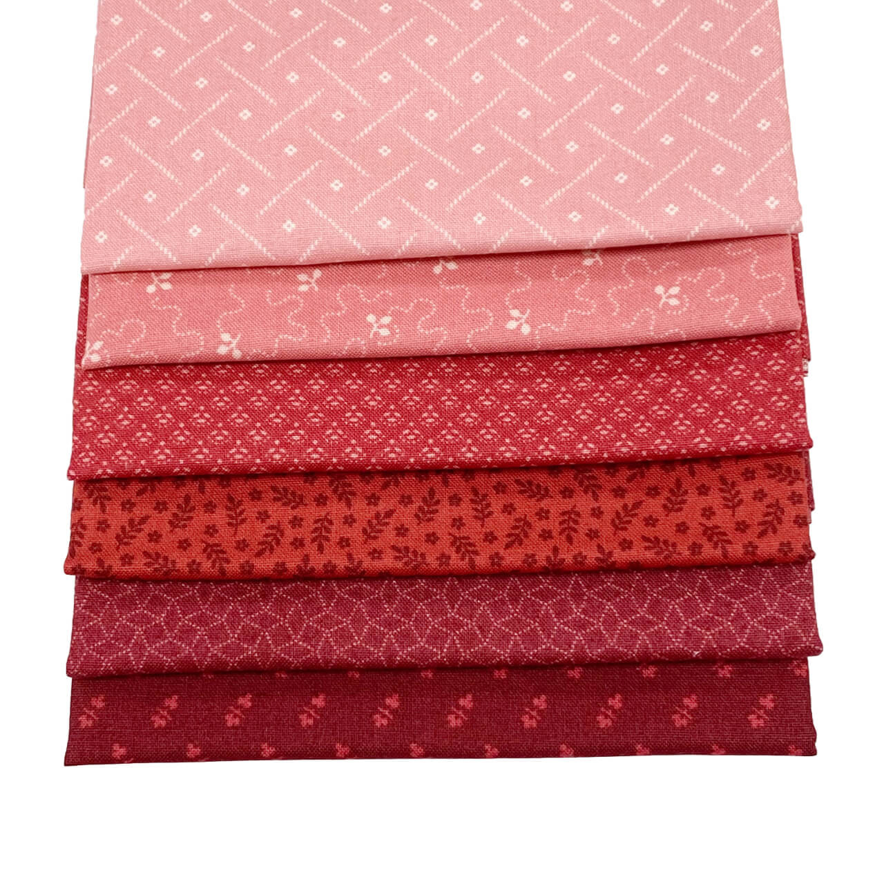 This image shows the 6 fat quarter fabrics from the Rouge colourway in the Tonal Ditzy Collection.