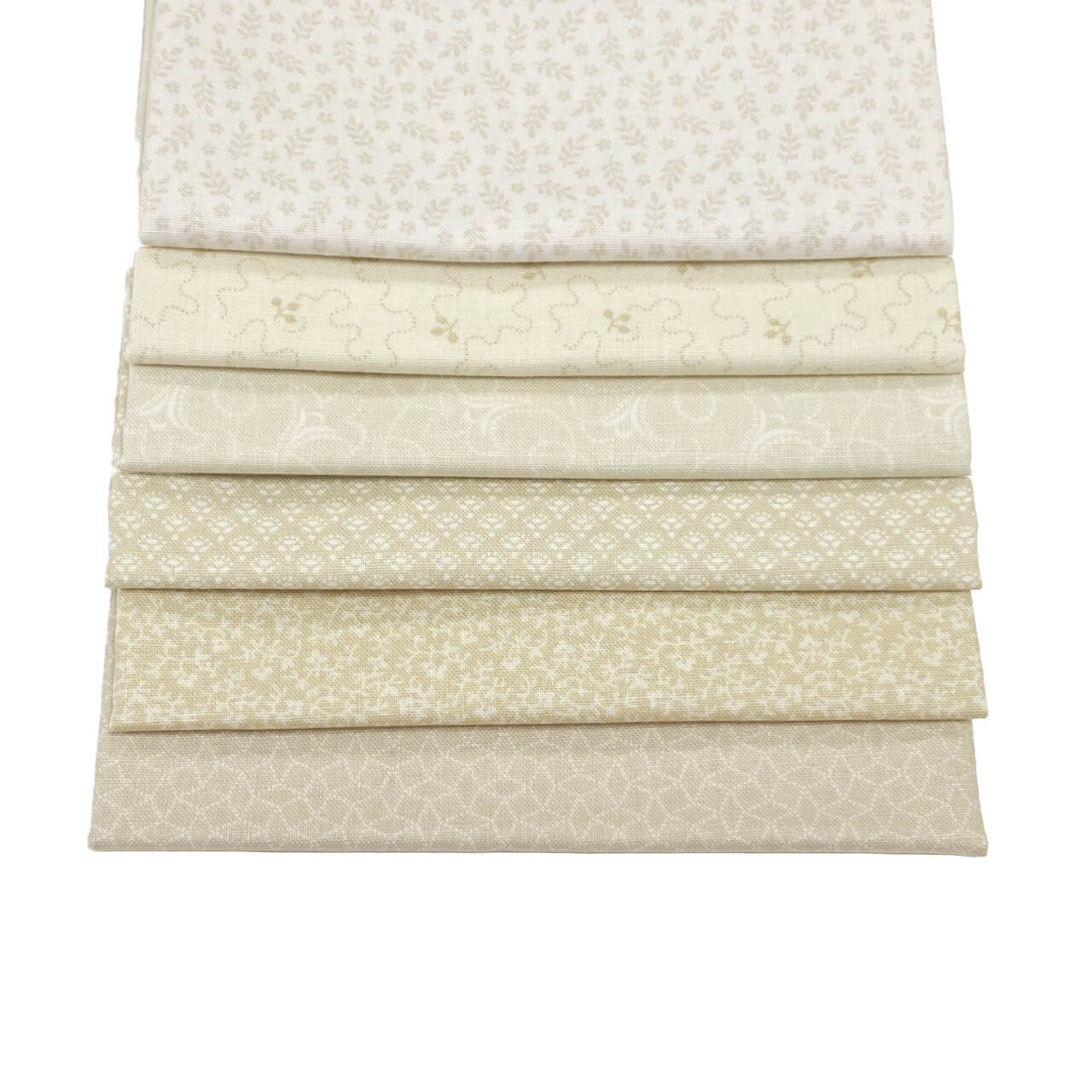 This image shows the 6 fat quarter fabrics from the Creme Fraiche colourway in the Tonal Ditzy Collection.