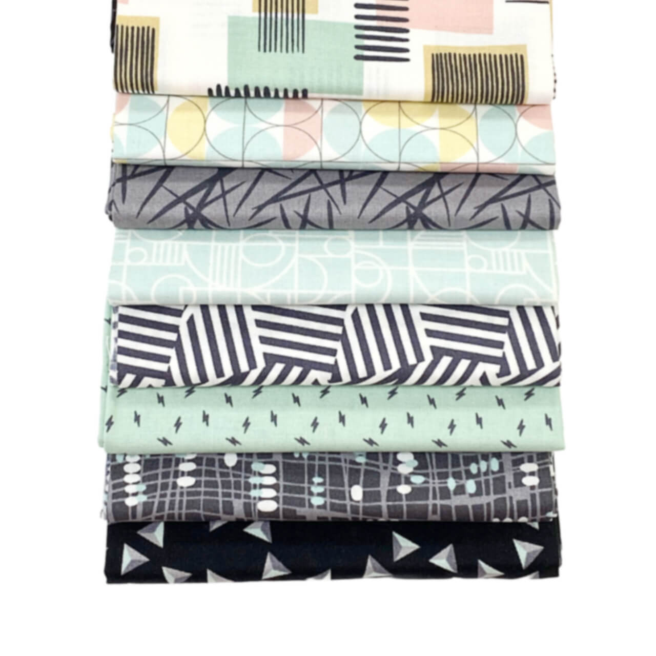 The image shows the 6 Sea Glass cascading fabric squares with geometric patterns in black, grey and turquoise pink. Bold shapes contrast with subtle designs, presenting a textured and varied assortment from the Rancho Relaxo series.