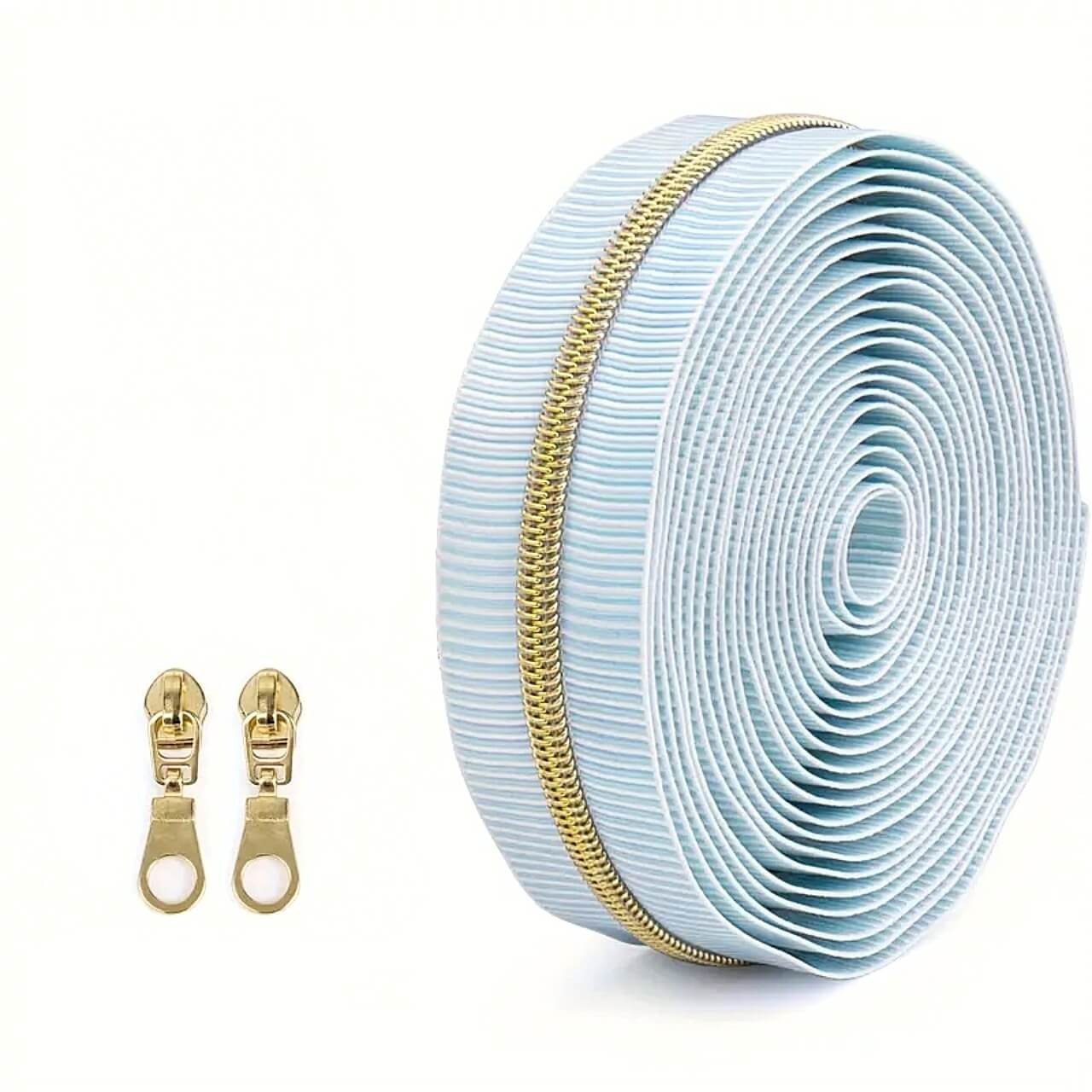 Pair of gold #5 teardrop pulls beside Blue Stripe zipper tape roll