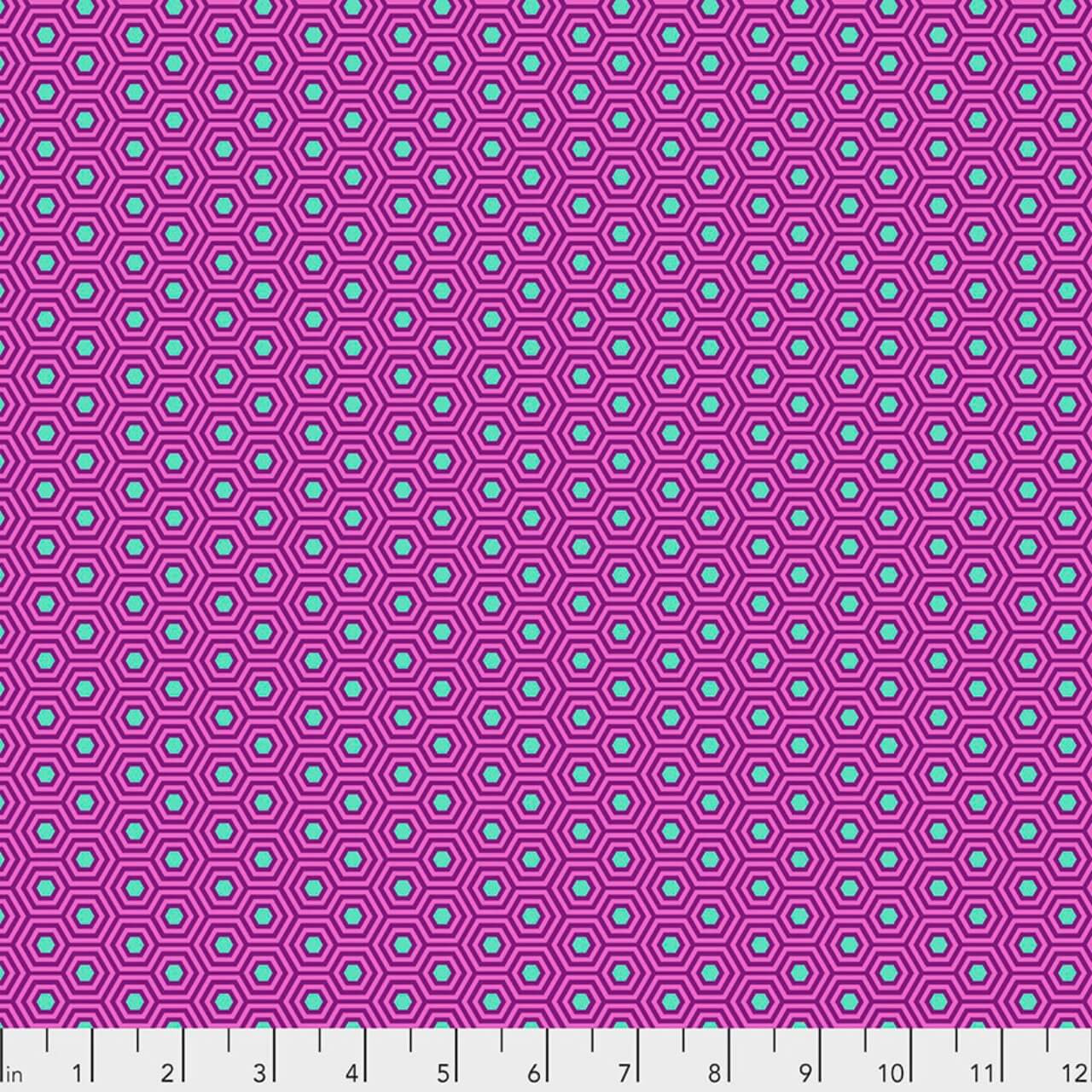 Hexy in Thistle by Tula Pink for FreeSpirit Fabrics featuring small aqua hexagons with layered purple outlines on a vibrant pink background from the True Colors collection.