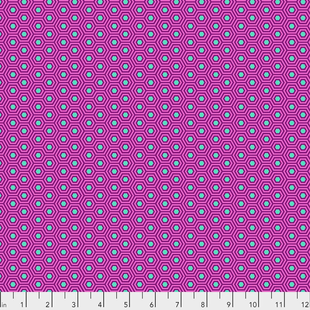 Hexy in Thistle by Tula Pink for FreeSpirit Fabrics featuring small aqua hexagons with layered purple outlines on a vibrant pink background from the True Colors collection.