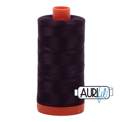 A large spool of Aurifil Aubergine 50wt Egyptian cotton thread in dark purple with Aurifil logo