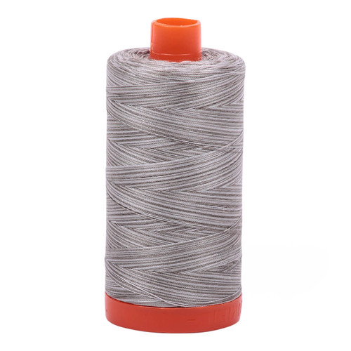 Large spool of Aurifil Silver Fox 50wt Egyptian cotton thread, variegated grey.