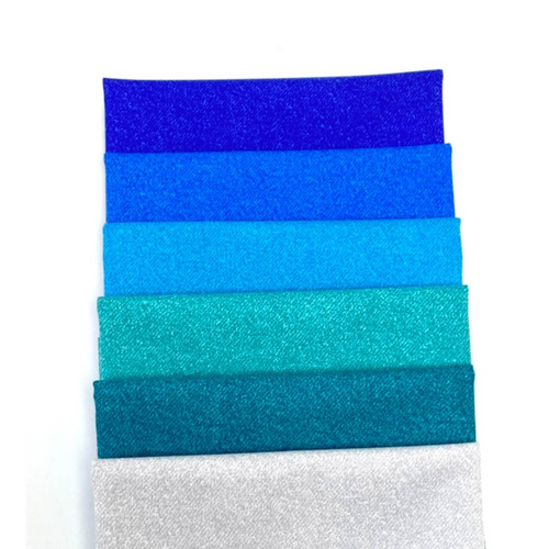 Gradient stack of Phosphor Electric Buzz fat quarters in shades of blue to teal on a white surface.