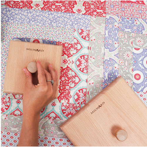 The Milward Quilter's Clapper Square in use, with a hand pressing the clapper on a colourful quilted fabric next to a steam iron. The Milward Quilter's Clapper Square in use, with a hand pressing the clapper on a colourful quilted fabric next to a steam iron.