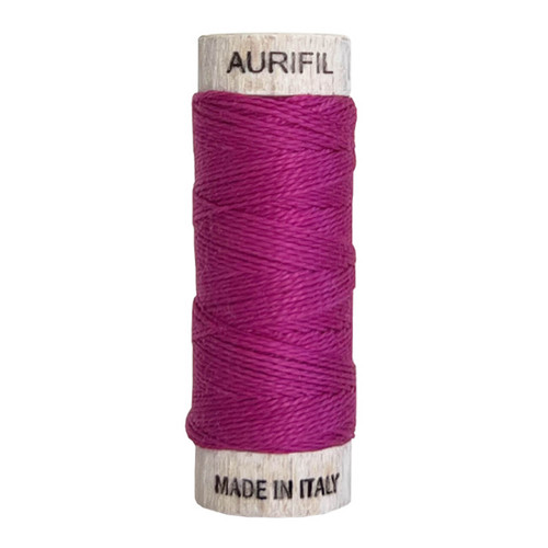 Aurifil 8wt cotton thread in Magenta (colour 2535), shown on wooden spool
