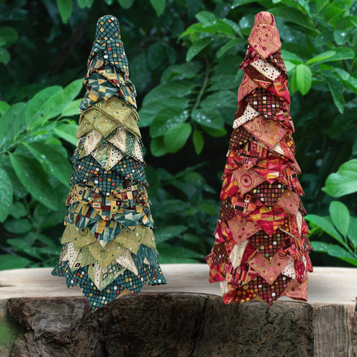 Pair of no-sew fabric trees in prints from Makower's Golden collection in green and red, displayed outdoors in a garden setting.