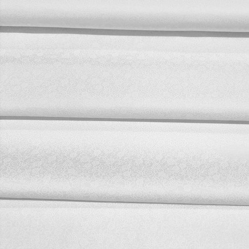 Fabric Freedom Flower Patch white-on-white cotton quilting fabric folded to display the delicate outlined floral design.