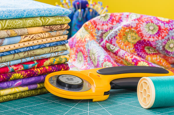 Vibrant Foliage & Floral Fabric in a pile on a quilting table