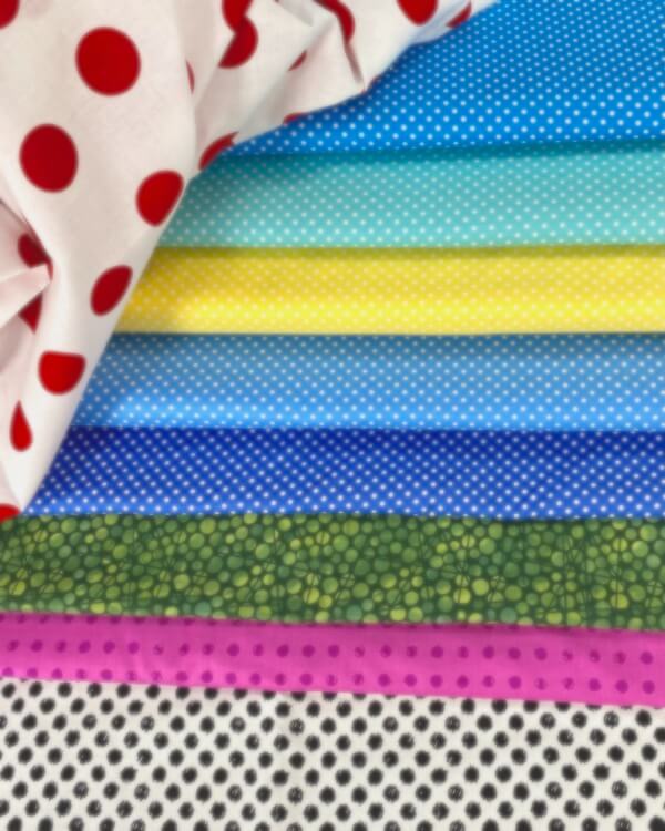 Spots, Dots & Dashes: A World of Playful & Dynamic Fabric Prints stacked together in a pile