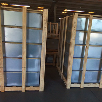 Two wood-crated stacks of Curbs Plus CPC-3 roof curbs in a warehouse