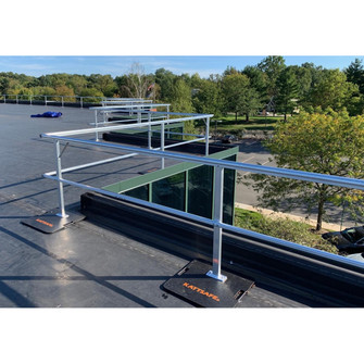 White aluminum KattGuard GR34 freestanding guardrail installed along a flat roof edge