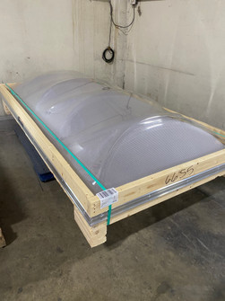 Kingspan KT12 triarch dome skylight crated in a wooden shipping frame, warehouse photo