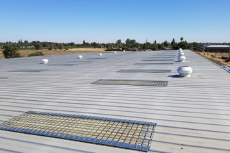 Metal roof with multiple Saf-T-Screen wire safety screens installed near roof vents
