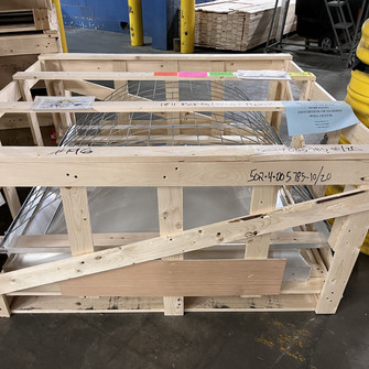 Velux shrink-out smoke vent dome and wire safety cage packed together in a wood shipping crate with fragile labels