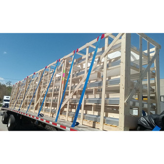 Large wood shipping crate containing Velux smoke vents strapped to a flatbed truck trailer