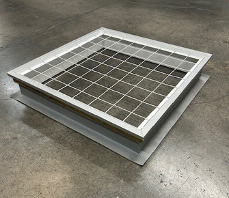 White primed roof curb with a pre-installed 4 inch on-center safety screen, shown on a warehouse floor
