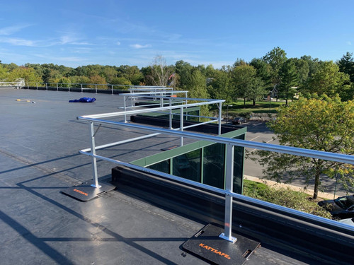 White aluminum KattGuard GR34 freestanding guardrail installed along a flat roof edge