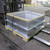 Forklift loading a galvanized roof curb with safety grid, banded to a pallet in a manufacturing yard