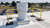 Yellow rooftop guardrail encircling a large exhaust stack, with a parking lot visible below