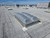 Close-up of a Kingspan bubble-domed smoke vent installed on a roof with HVAC units nearby