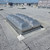 Close-up of a Kingspan aluminum double-door smoke vent installed on an aged white membrane roof