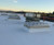 Kingspan smoke vents installed on a commercial roof at dusk, industrial rail yard in the background