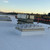 Kingspan smoke vents installed on a commercial roof at dusk, industrial rail yard in the background