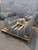 Stacks of wire mesh exterior fall-protection screens strapped to wooden pallets for shipping