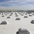 Rows of Sunoptics dome skylights installed across a flat commercial roof under a hazy sky