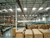 Distribution center interior with stacked boxes and conveyors lit by skylight daylighting