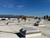 Wide view of several domed roof vents across a white TPO roof with snow-capped mountains in the distance