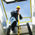 Low-angle shot of a worker descending a fixed ladder through a hatch, holding the yellow LU-1 post