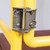 Close-up of the spring-loaded self-closing hinge mechanism on the yellow guardrail gate